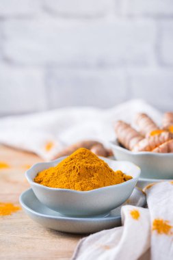 Yiyecek ve içecek, diyet beslenme, sağlık konsepti. Çiğ organik turuncu zerdeçal kökü ve toz, yemek masasında sokağa çıkma yasağı. Hint asıllı düşük kolesterol baharatları. Boşluk arkaplanı kopyala