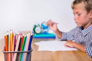 Evlat, öğrenci çalışıyor, öğreniyor, evden ders çalışıyor, not defterine not alıyor. Öğrenci, eğitim, evde kalmak, evde eğitim kavramı.