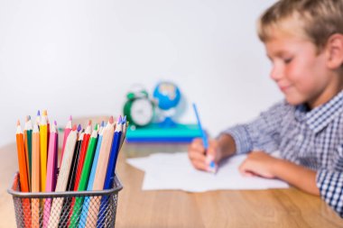 Evlat, öğrenci çalışıyor, öğreniyor, evden ders çalışıyor, not defterine not alıyor. Öğrenci, eğitim, evde kalmak, evde eğitim kavramı.