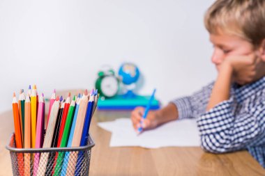 Evlat, öğrenci çalışıyor, öğreniyor, evden ders çalışıyor, not defterine not alıyor. Öğrenci, eğitim, evde kalmak, evde eğitim kavramı.