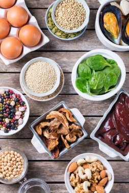 Sağlıklı beslenme diyeti konsepti. Yüksek demir içerikli yiyecekler. Sığır ciğeri, ıspanak, yumurta, baklagil, fındık, mantar, kinoa, susam, kabak çekirdeği, soya fasulyesi, deniz ürünleri. Düz yatıyordu 