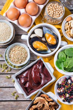 Sağlıklı beslenme diyeti konsepti. Yüksek demir içerikli yiyecekler. Sığır ciğeri, ıspanak, yumurta, baklagil, fındık, mantar, kinoa, susam, kabak çekirdeği, soya fasulyesi, deniz ürünleri. Düz yatıyordu 