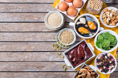 Sağlıklı beslenme diyeti konsepti. Yüksek demir içerikli yiyecekler. Sığır ciğeri, ıspanak, yumurta, baklagil, fındık, mantar, kinoa, susam, kabak çekirdeği, soya fasulyesi, deniz ürünleri. Uzayı kopyala, düz yat 