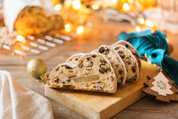 Seasonal food and drink, winter concept. Traditional European German homemade Christmas cake, pastry dessert Stollen on a wooden backgrounds with festive decoration.