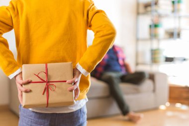 Babalar günü tatili. Sevimli genç çocuk babasına el yapımı bir hediye kutusu veriyor. Mutlu aile, birlikte vakit geçirmek, evde kalmak..