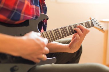 Genç milenyum adamı, elektro gitar çalan adam. Evde kal, ev aktivitesi, öğrenme dersleri.