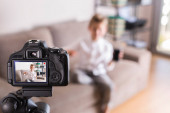 Vlogger nahrávání videa sociálních médií, zatímco sedí na gauči