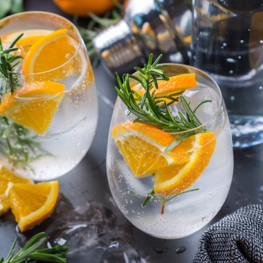 Portakal, biberiye ve barmen aksesuarlarıyla sert maden suyu kokteyli.