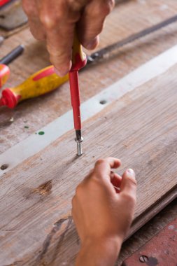 Dedem çocuklara doğrama aletleriyle bankta çalışmayı öğretiyor.