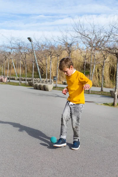 Elegante menino bonito, adolescente está brincando com bola, ao ar livre — Fotografia de Stock