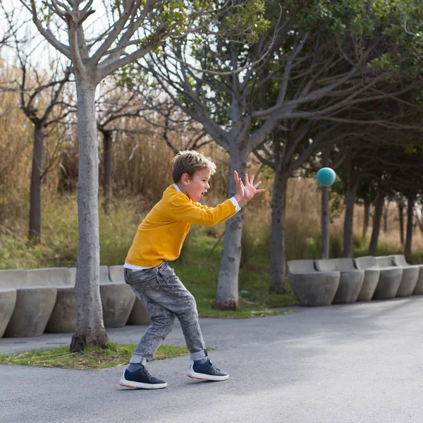 Elegante menino bonito, adolescente está brincando com bola, ao ar livre — Fotografia de Stock
