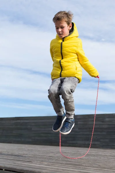 Rapaz elegante, adolescente está pulando com corda pulando, ao ar livre — Fotografia de Stock
