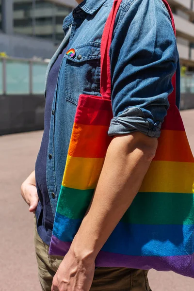 Hombre con bolsa reutilizable arco iris e insignia lgbt, mes de orgullo —  Fotos de Stock