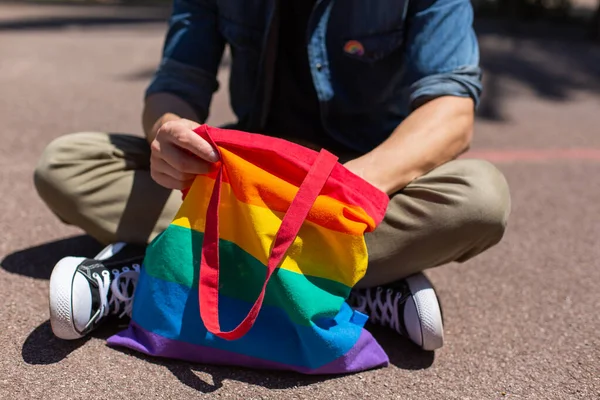 Hombre con bolsa reutilizable arco iris e insignia lgbt, mes de orgullo —  Fotos de Stock