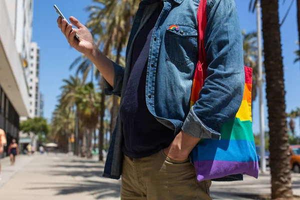 Homem com saco reutilizável arco-íris e crachá lgbt, mês de orgulho — Fotografia de Stock