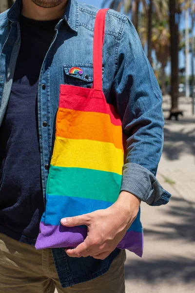 Man med regnbåge återanvändbar väska och lgbt badge, stolthet månad — Stockfoto