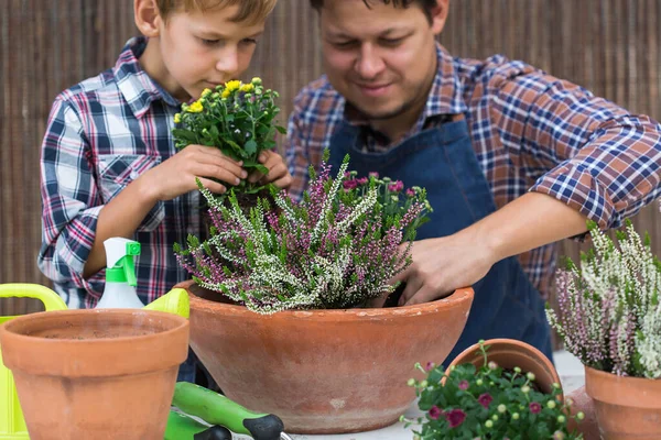 子供は父親が花を植えるのに役立ちます。家庭での家族の時間 — ストック写真