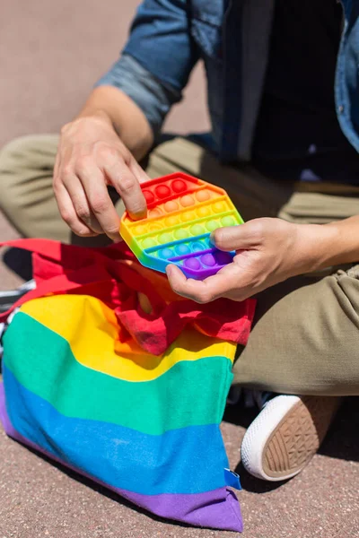 Man med regnbåge pop det leksak, lgbt väska, stolthet månad — Stockfoto