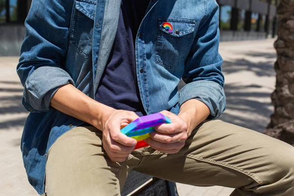 Uomo con arcobaleno pop esso giocattolo, distintivo lgbt, mese di orgoglio — Foto Stock