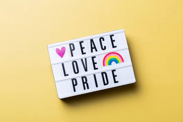 Мир любові текст гордості, веселка lgbtq прапор на жовтому тлі — стокове фото