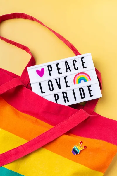 Fred kärlek stolthet text, regnbåge återanvändbar väska mot gul bakgrund — Stockfoto
