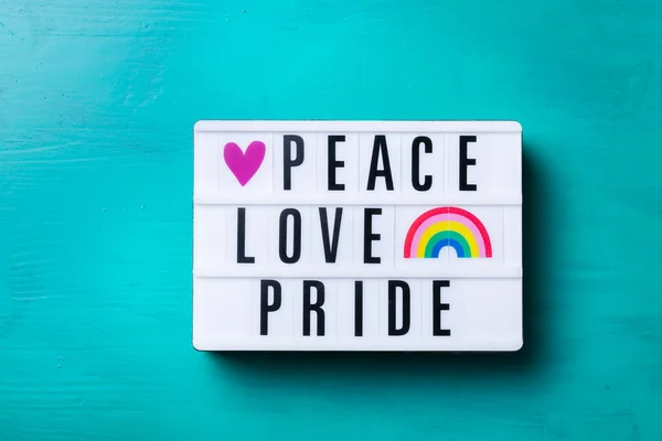 Мир любові текст гордості, веселка lgbtq прапор на бірюзовому фоні — стокове фото