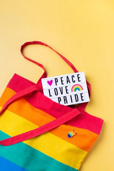 Fred kärlek stolthet text, regnbåge återanvändbar väska mot gul bakgrund — Stockfoto