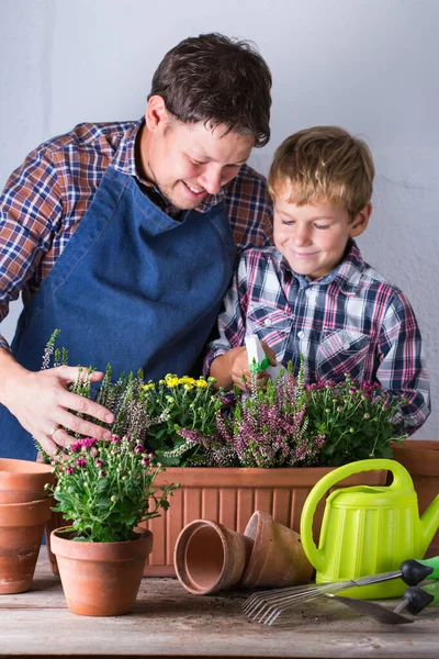 子供は父親が花を植えるのに役立ちます。家庭での家族の時間 — ストック写真