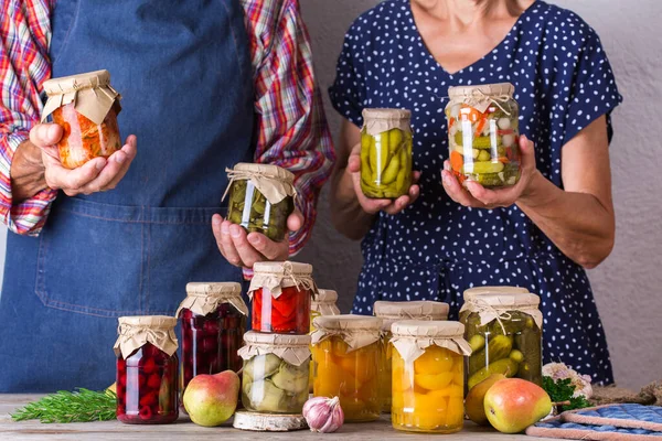 Senior couple holding in hands preserved food — Stock Photo, Image