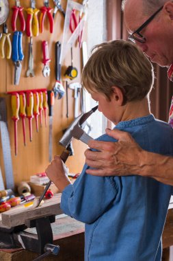Dedem çocuklara doğrama aletleriyle bankta çalışmayı öğretiyor.