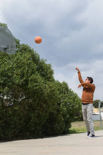 Jovem elegante está jogando com bola, ao ar livre — Fotografia de Stock