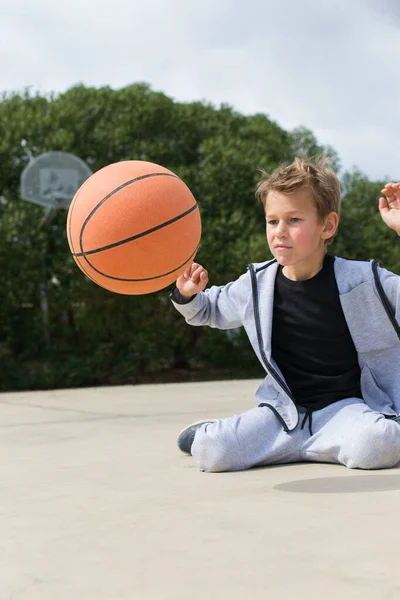 Stilvoller kleiner Junge, Teenager spielt mit Ball, im Freien — Stockfoto