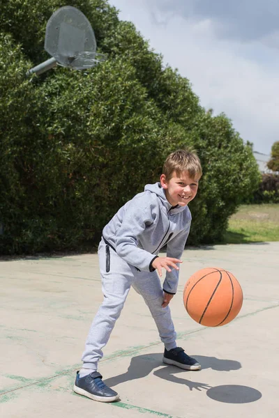 Elegante menino, adolescente está brincando com bola, ao ar livre — Fotografia de Stock