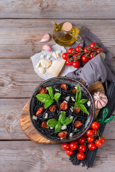 토마토, 치즈,바질 이 함유된 검은 스파게티 파스타 — 스톡 사진