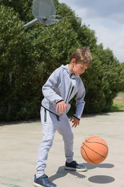 Elegante menino, adolescente está brincando com bola, ao ar livre — Fotografia de Stock