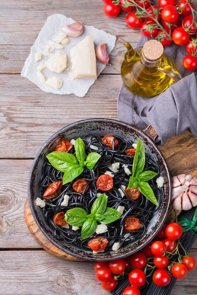 토마토, 치즈,바질 이 함유된 검은 스파게티 파스타 — 스톡 사진