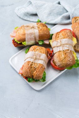 Jambon, marul ve domatesli taze ekmek sandviçi.