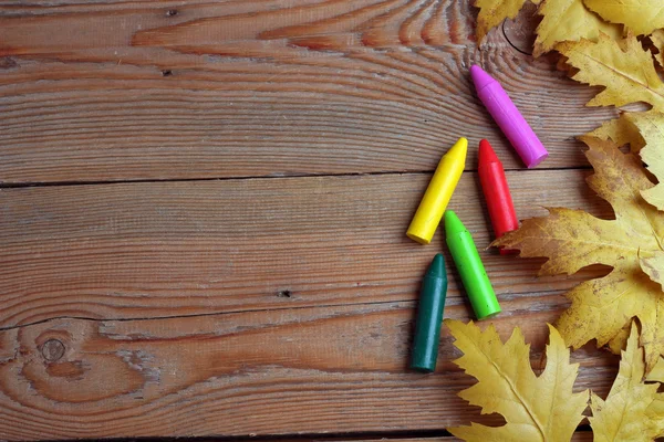 Background with crayons and maple leaves — Stock Photo, Image
