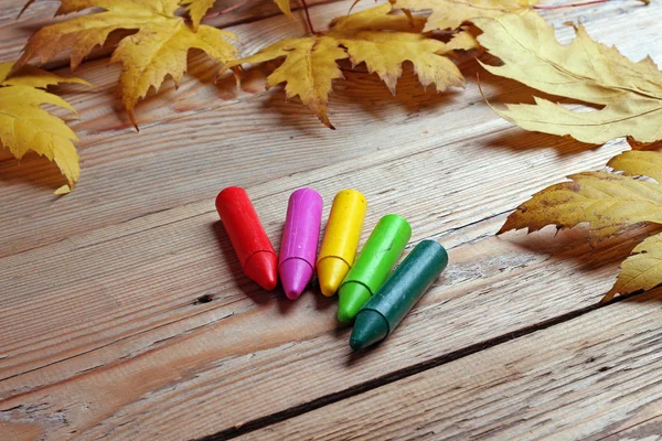 Crayons and maple leaves — Stock Photo, Image