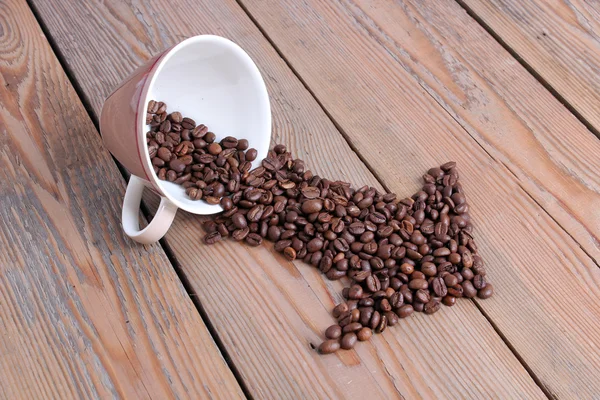 木製テーブルの上のコーヒー豆とカップ — ストック写真