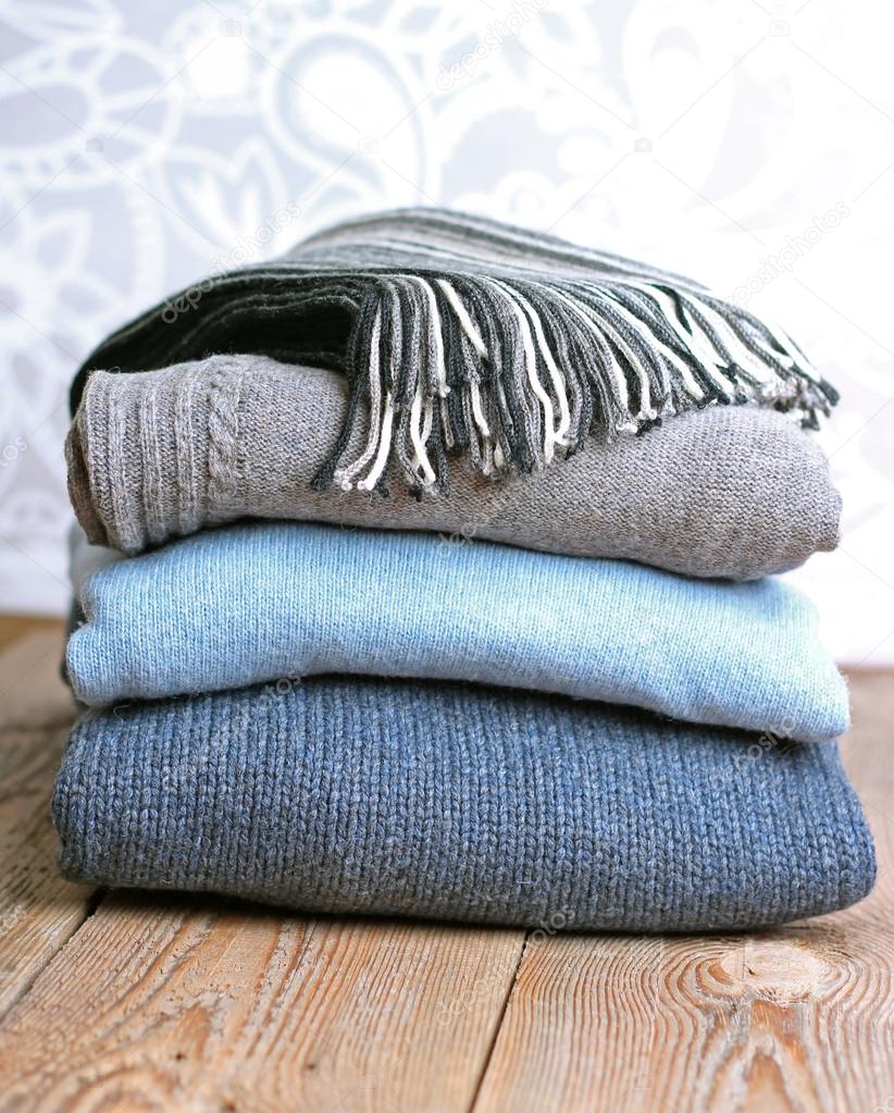 Pile of warm wool clothing on a wooden table