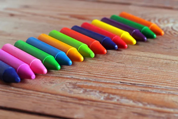 Oil pastel crayons lying on a wooden table — Stock Photo, Image