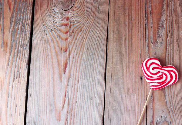 Heart shaped lollipop for Valentine's Day with wooden background — Stock Photo, Image