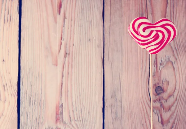 Hartvormige Lolly voor Valentijnsdag met houten achtergrond — Stockfoto