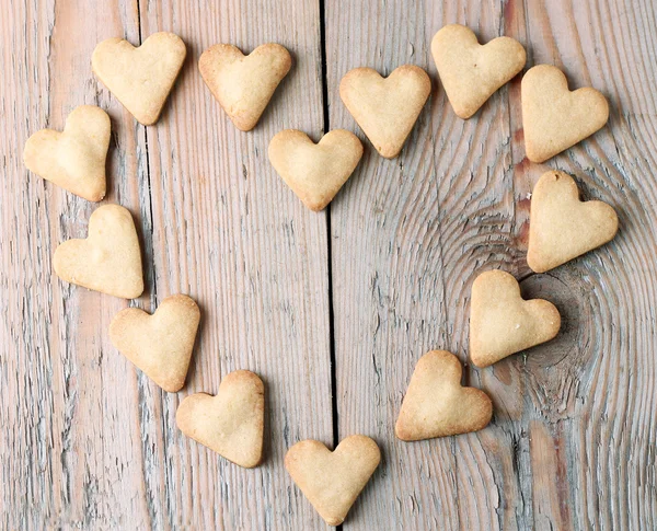 Soubory cookie na dřevěný stůl pro den svatého Valentýna ve tvaru srdce — Stock fotografie