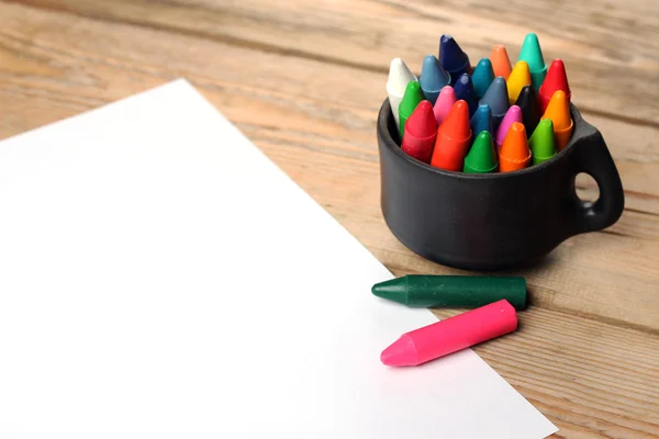 Lápices de colores pastel al óleo en una taza sobre una mesa de madera — Foto de Stock