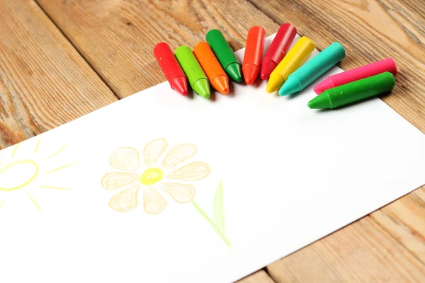 Lápices de colores pastel al óleo sobre un papel con flores y sol pintados — Foto de Stock