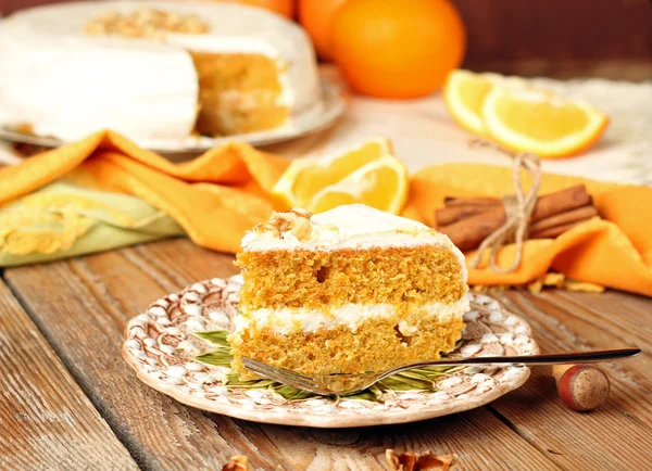 Ciasto z marchwi na drewnianym stole z pomarańcze, orzechy i cynamon — Zdjęcie stockowe