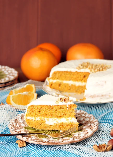 Karottenkuchen auf einem Holztisch mit Orangen — Stockfoto