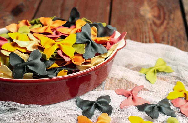 Raw and dry pasta on a wooden background — Stock Photo, Image